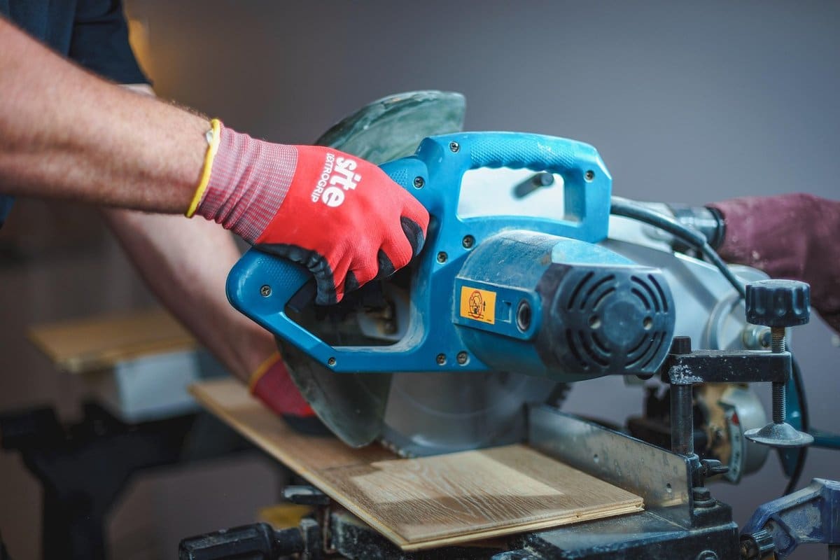 A tradesman mid-career using a power tool on a hands-on job site project